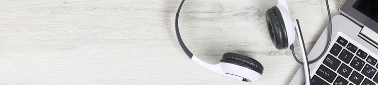 a set of headphones on a laptop on a wooden desk
